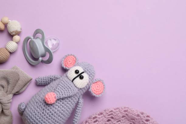 istock Flat lay composition with pacifier and other baby stuff on violet background. Space for text 1824816409