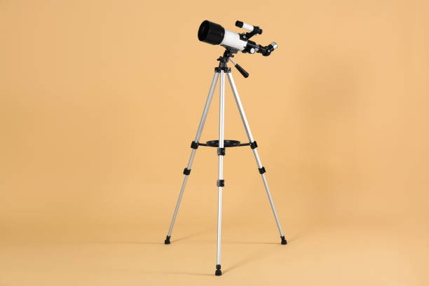 istock Tripod with modern telescope on beige background 1824819077