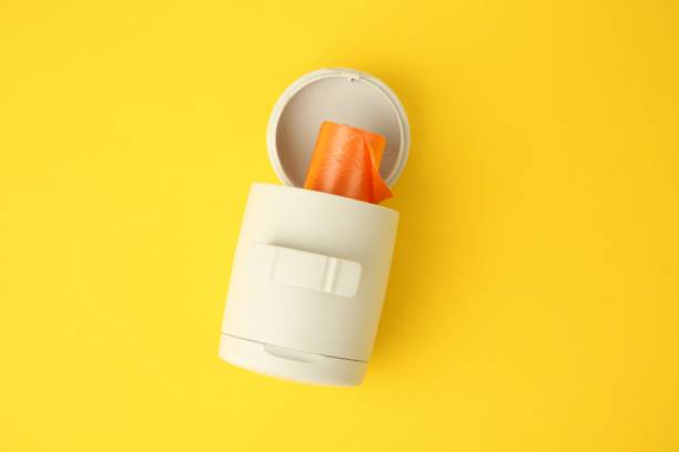 istock Dispenser with dog waste bags on yellow background, top view 1824819084