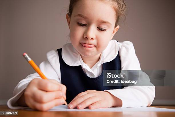 Foto de Garota Jovem Estudante Escrever Sentado Em Uma Mesa De Escola e mais fotos de stock de 6-7 Anos