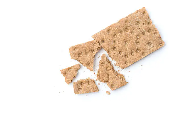 Crunchy crispbread with crumbs on white background.