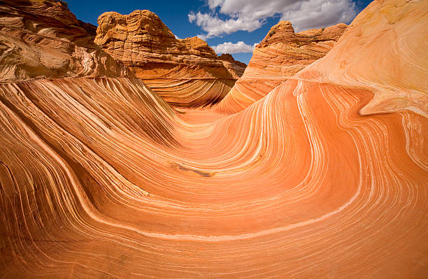 The Wave at Coyote Buttes "Late afternoon sun richly lights the colorful sandstone shapes of the Wave. This unique geological feature is a combination of textures, shapes, and colors. Taken at Coyote Buttes, Arizona." coyote buttes stock pictures, royalty-free photos & images
