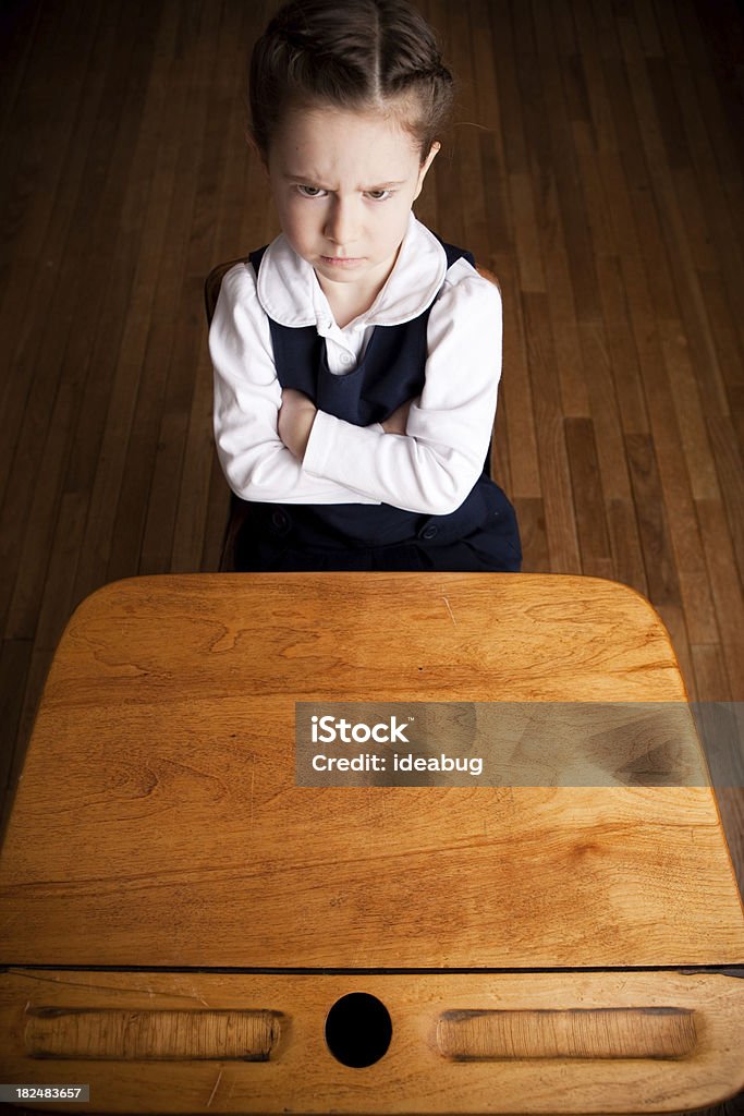 Perturbar Scowling garota estudante na escola de estar e escrivaninha - Foto de stock de 6-7 Anos royalty-free