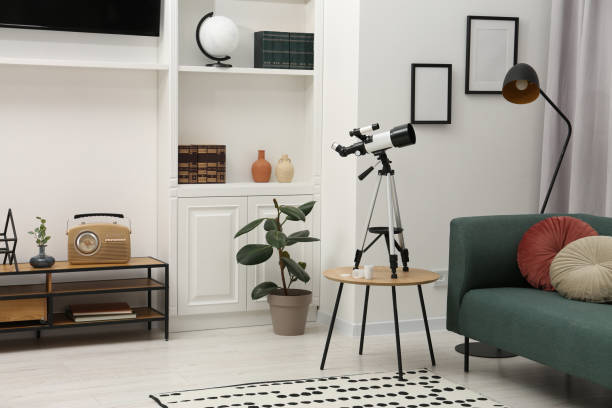 istock Tripod with modern telescope on table in living room 1824838649