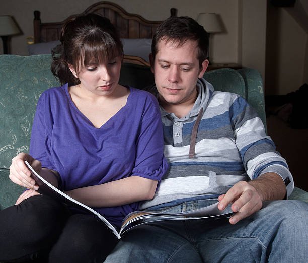 istock Happy young couple looking at brochure 182483996