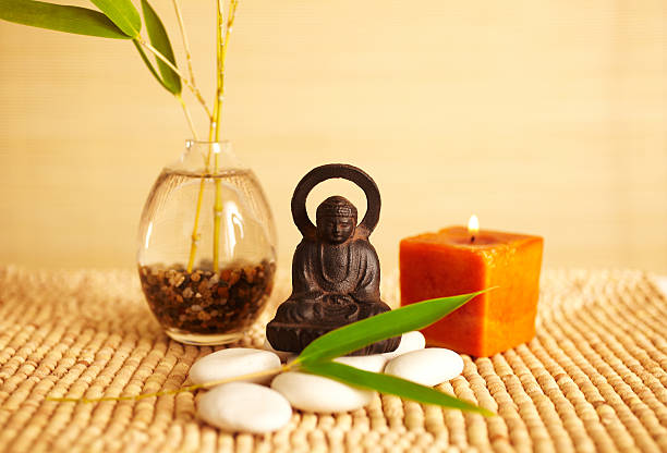 спа натюрморт статуи будды и свеча - bamboo zen like buddhism spa treatment стоковые фото и изображения