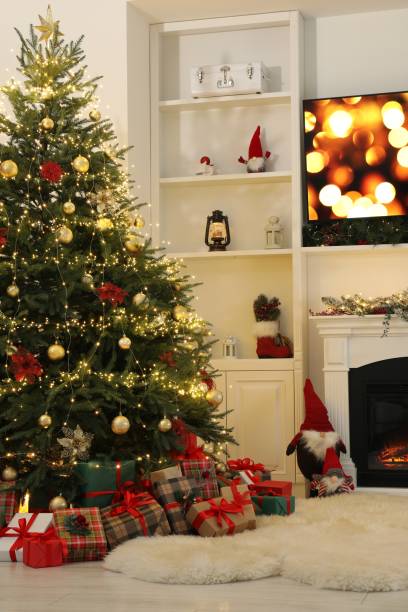 istock Many gift boxes under Christmas tree decorated with ornaments and festive lights in room 1824840848