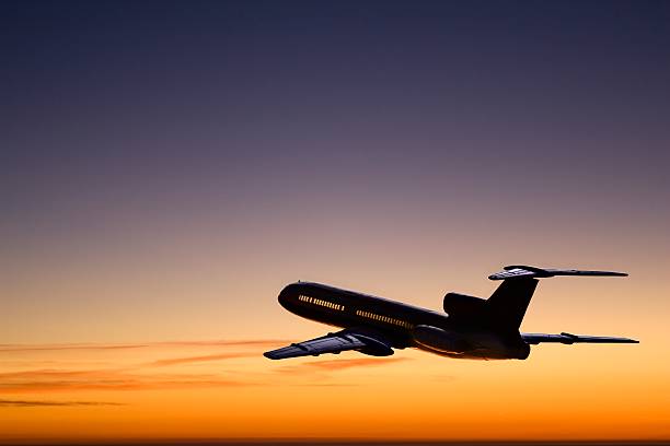 Afterglow. Passenger airplane silhouette on the evening-glow background.