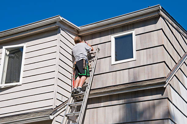 istock Carpenter hanging cedar shingles on house 182484158