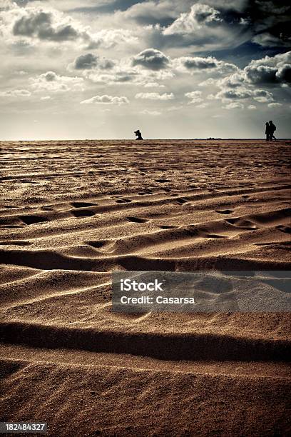 Foto de Silhuetas Na Praia Distante e mais fotos de stock de Andar - Andar, Areia, Contraluz