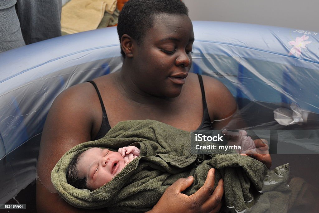 Baby Day~ Water Birth; checking toes mother in birthing tub examines newborn's feet Water Birth Stock Photo