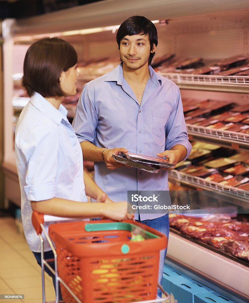 Szczęśliwa para zakup pakietów mięsa w supermarkecie. - Zbiór zdjęć royalty-free (20-24 lata)