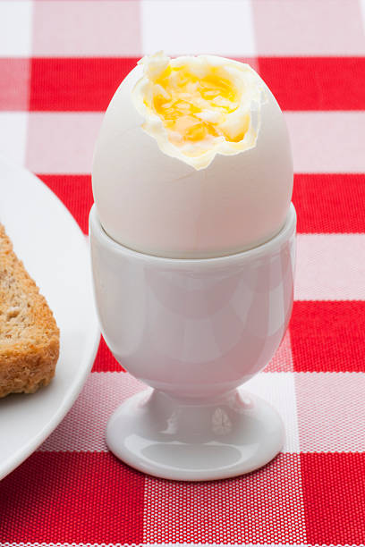 ソフトなゆで卵、フライパンにテーブルクロスの垂直 ストックフォト