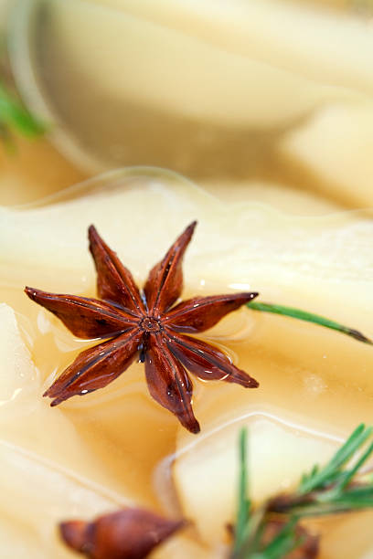 Homely christmas aromatherapy still life with anise star, cloves, cinnaplmon sticks and an orange slice on a wooden cutting board.  Color editing with added grain. Part of the christmas spices series.