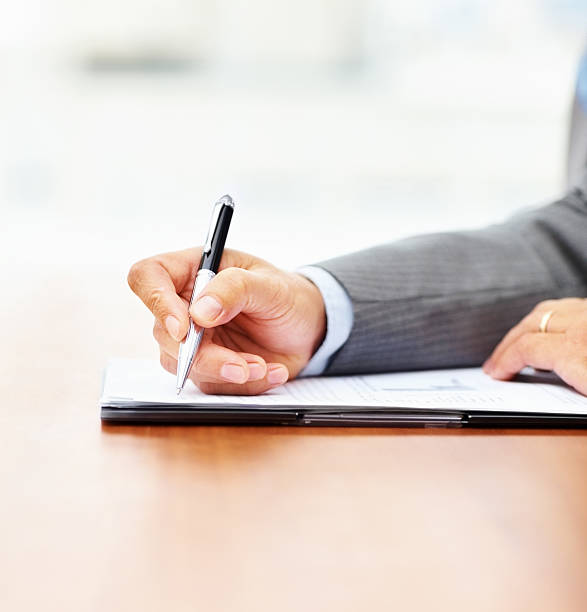 istock Cropped image of a businessman writing on notepad 182485796