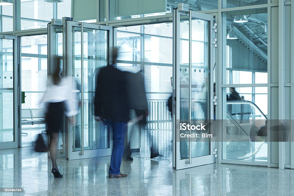 Persone a piedi alla porta d'ingresso dell'edificio moderno, Immagine mossa - Foto stock royalty-free di Entrata