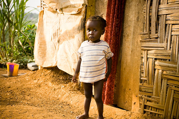 istock African girl standing outside her house 182488644