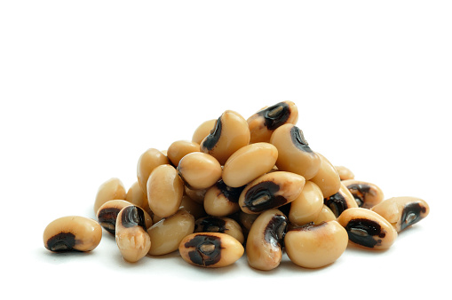 A close up shot of a pile of Black Eyed Peas isolated on white.