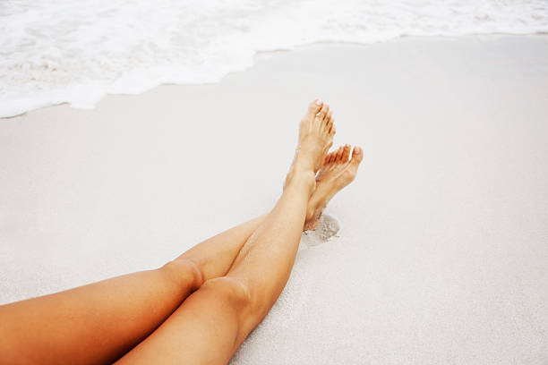 istock Woman's sexy legs on the beach 182490007