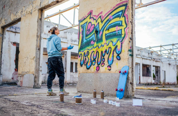 Young woman painting colorful graffiti on a wall