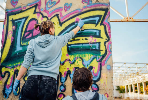 istock Friends painting colorful graffiti on a wall 1824902767