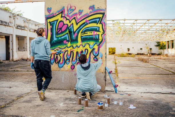 istock Friends painting colorful graffiti on a wall 1824905537