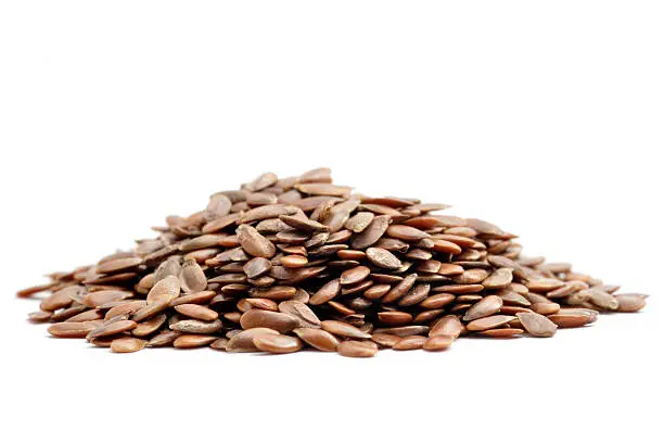 A close up shot of a pile of linseed isolated on white background.