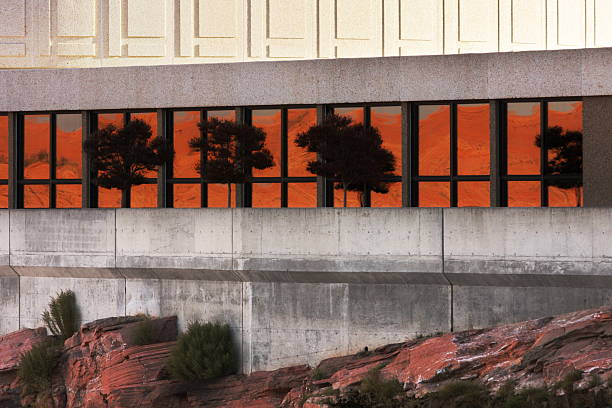 Concrete Building Architecture Desert Reflection "Modern glass and concrete architecture with intense autumn desert sunset reflecting off canyon walls in the window facade of the Visitor Center above the power generation levels of Glen Canyon Dam.  Glen Canyon National Recreation Area, 2009." glen canyon dam stock pictures, royalty-free photos & images