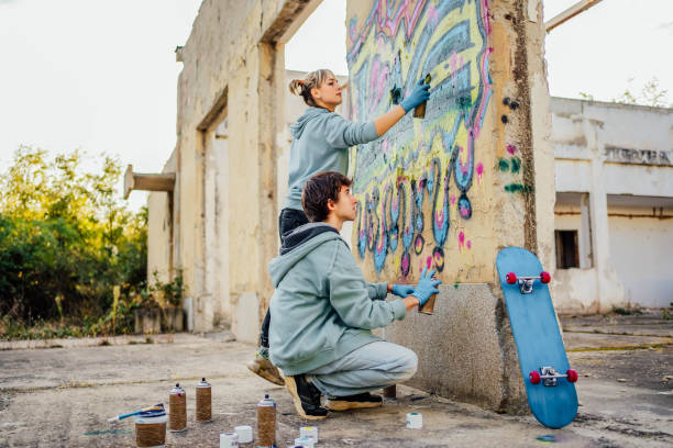 istock Friends painting colorful graffiti on a wall 1824906088