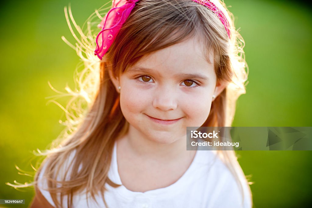 Ragazza felice sorridente mentre retroilluminato da sole di sera - Foto stock royalty-free di 4-5 anni