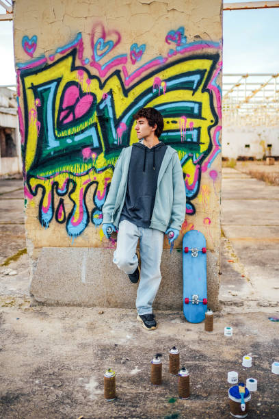 istock Young man standing in front of a graffiti wall 1824906603