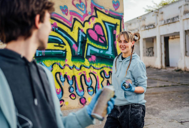 istock Friends painting colorful graffiti on a wall 1824906622