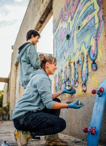 istock Friends painting colorful graffiti on a wall 1824907559
