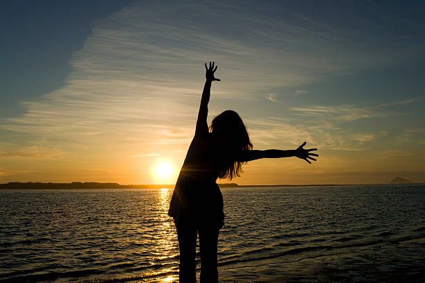 leuchtende silhouette der freude - heaven women sunrise inspiration stock-fotos und bilder