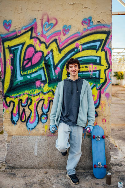 istock Young man standing in front of a graffiti wall 1824910560