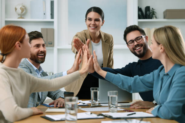istock Team of employees joining hands in office 1824910942