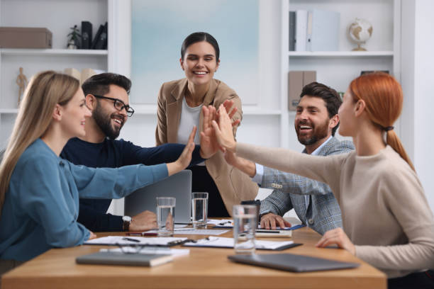 istock Team of employees joining hands in office 1824911145
