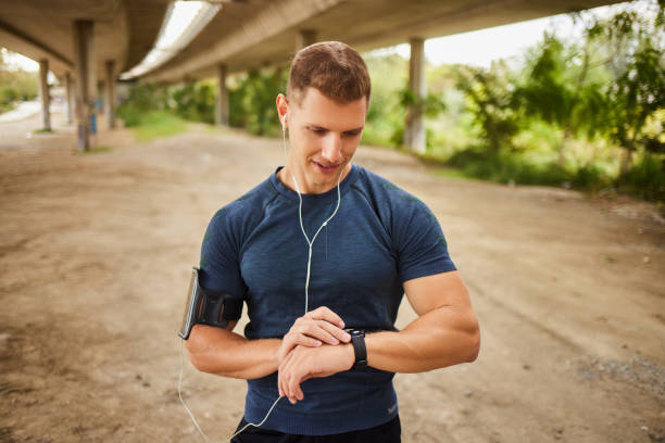 istock Male athlete looking at his smart watch or tracker under the bridge 1824911150