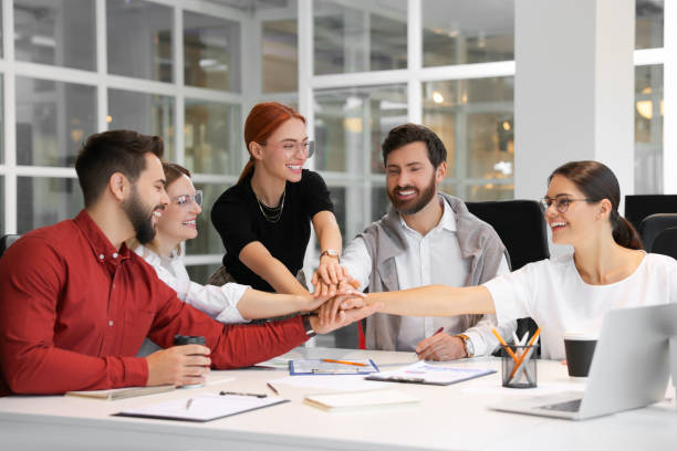 istock Team of employees joining hands in office 1824911224