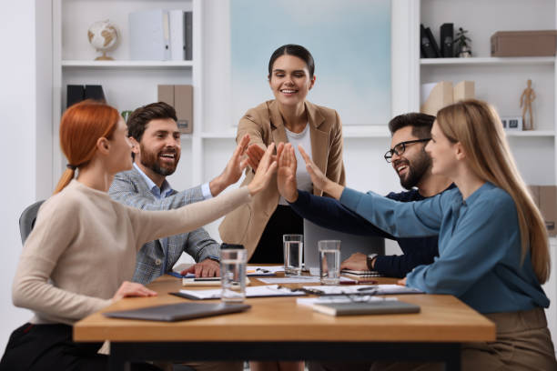 istock Team of employees joining hands in office 1824911665