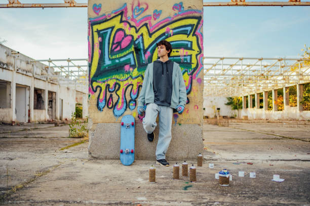 istock Young man standing in front of a graffiti wall 1824915375