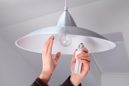 Person Changing Bulbs to Save Energy