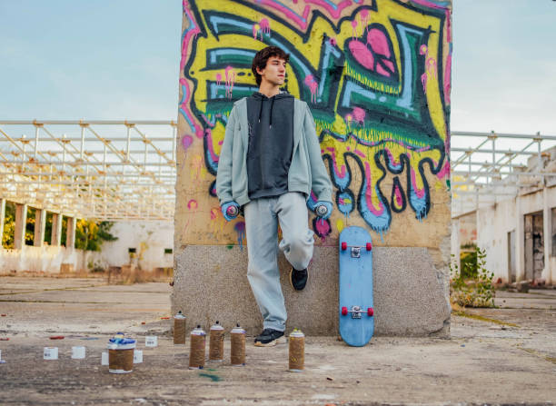 istock Young man standing in front of a graffiti wall 1824918063