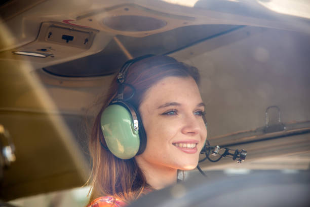 istock Smiling young woman in the cockpit, flying a small single engine airplane. 1824920257