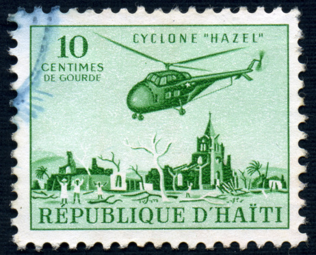 A ten Centime Haitian postage stamp issued in 1955 depicting a relief helicopter over Haiti after Hurricane Hazel.