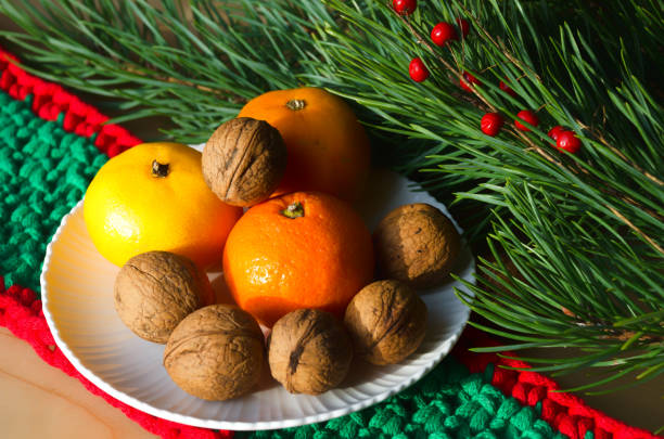 Tangerines and walnuts on a New Year's background. Decorations for the New Year and Christmas.