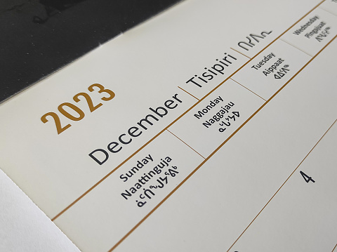 A calendar for December 2023 with English and Inuktitut languages