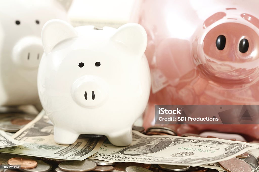 Piggy Banks Laying on Piles of Cash Piggy Banks Laying on Piles of Cash.See more money photos: 401k - Single Word Stock Photo