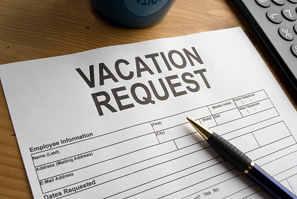 istock Vacation request form and pen on a wooden desk 182495788