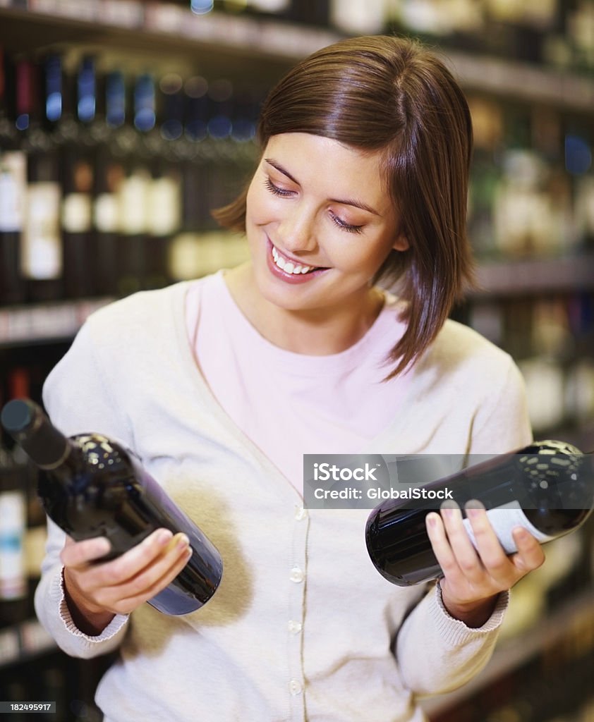 Счастливая женщина, выбор вина бутылки в Супермаркет - Стоковые фото Вино роялти-фри